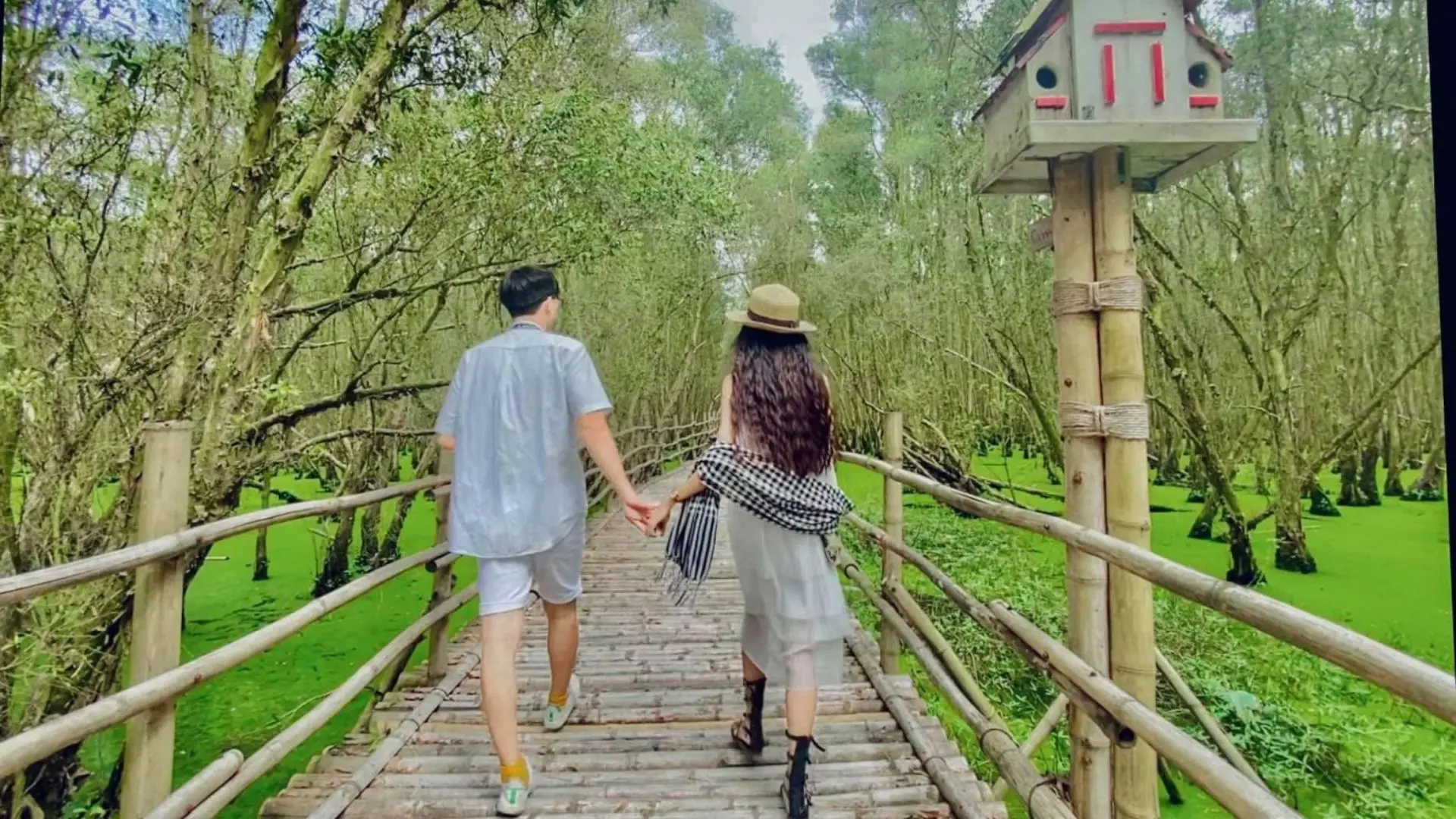 Du khách chụp hình trên cây cầu tre huyền thoại.
