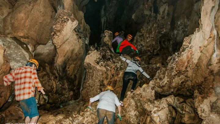 Đoàn khách leo mỏm đá gồ ghề, khám phá Hang Chà Lòi.