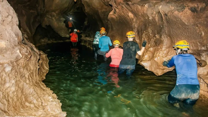 Đoàn khách lội qua khu vực ngập nước, trải nghiệm Hang Chà Lòi