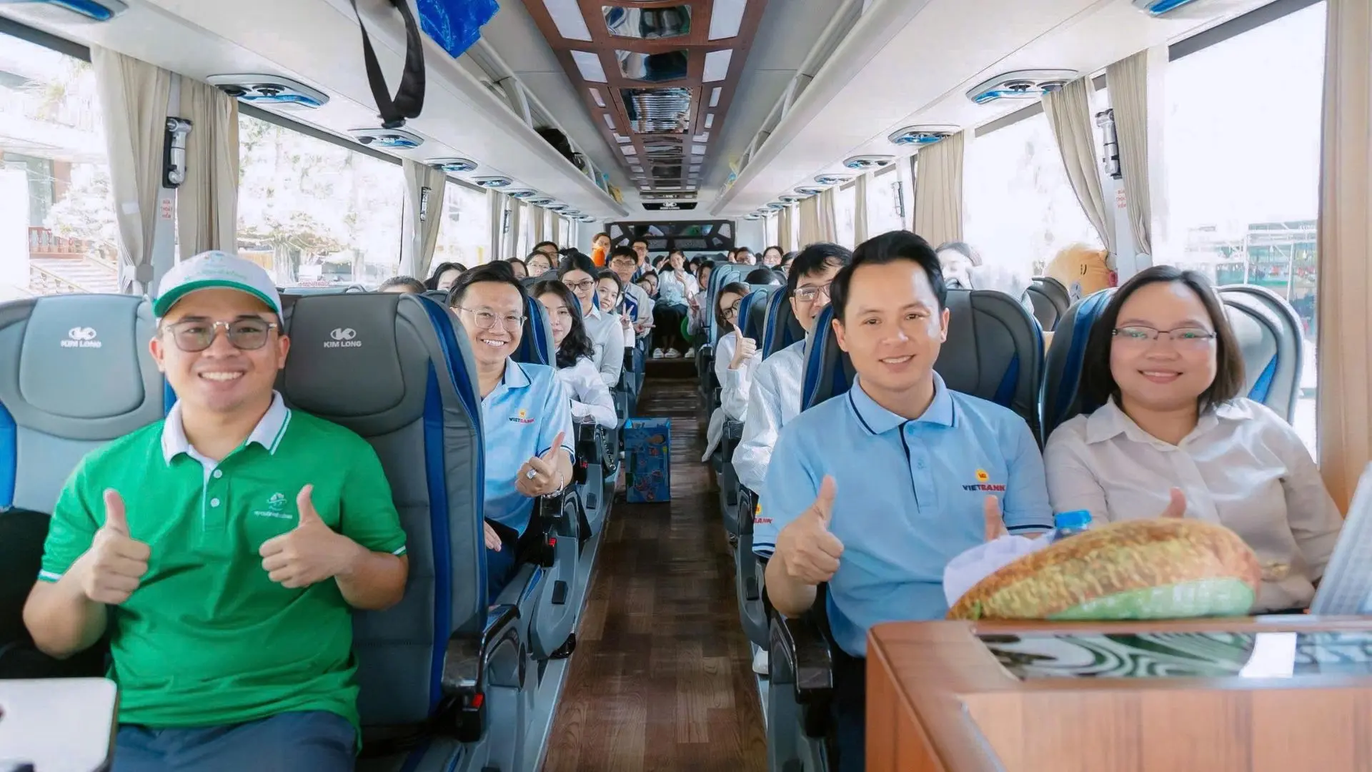 Hướng dẫn viên và sinh viên hào hứng trên xe du lịch trong chuyến Vietbank Study Tour