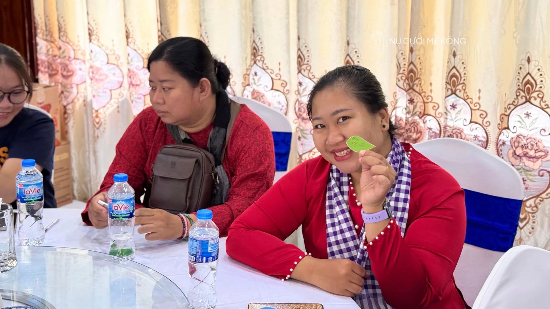 Khách mời mặc áo bà ba và khăn rằn cầm chiếc lá xanh tại Smile Guide Day 2026