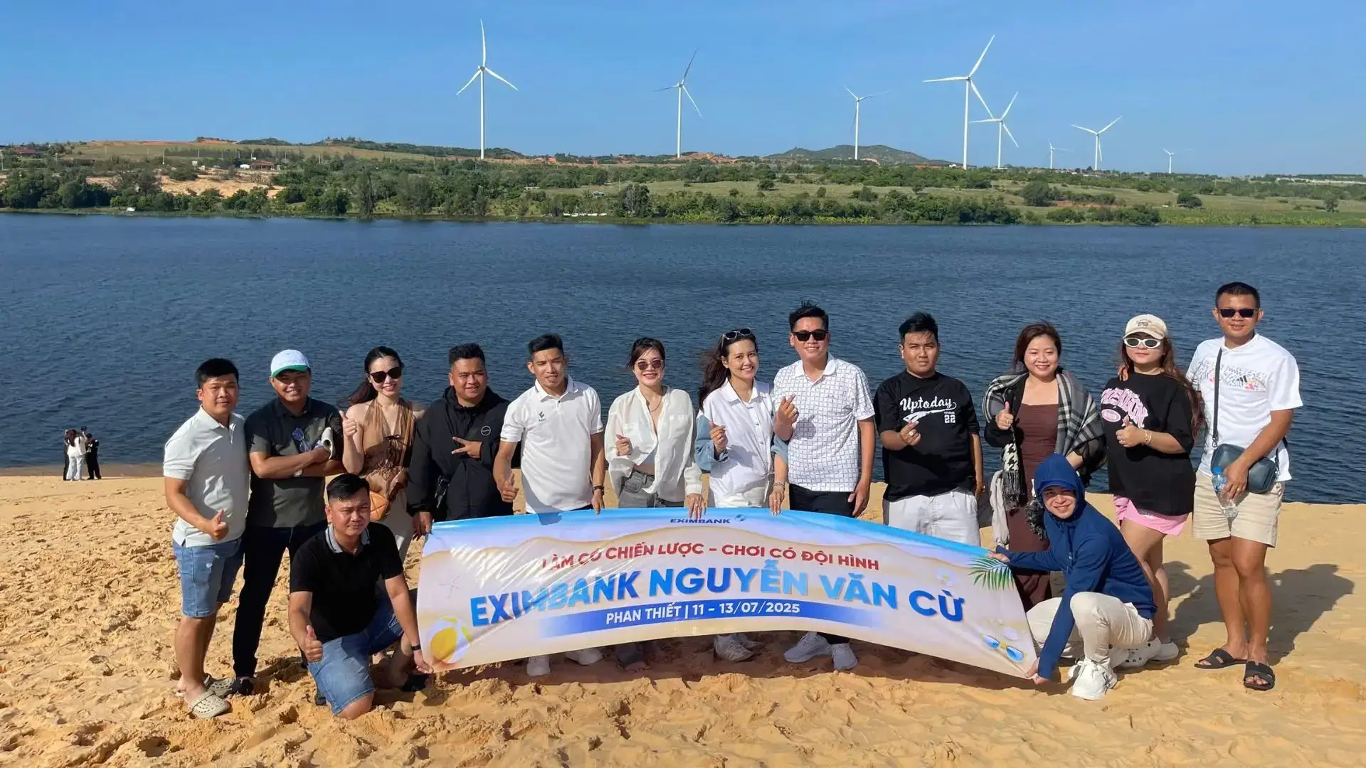 Tour đoàn Eximbank Cần Thơ tại Phan Thiết chụp ảnh tập thể cùng banner chương trình