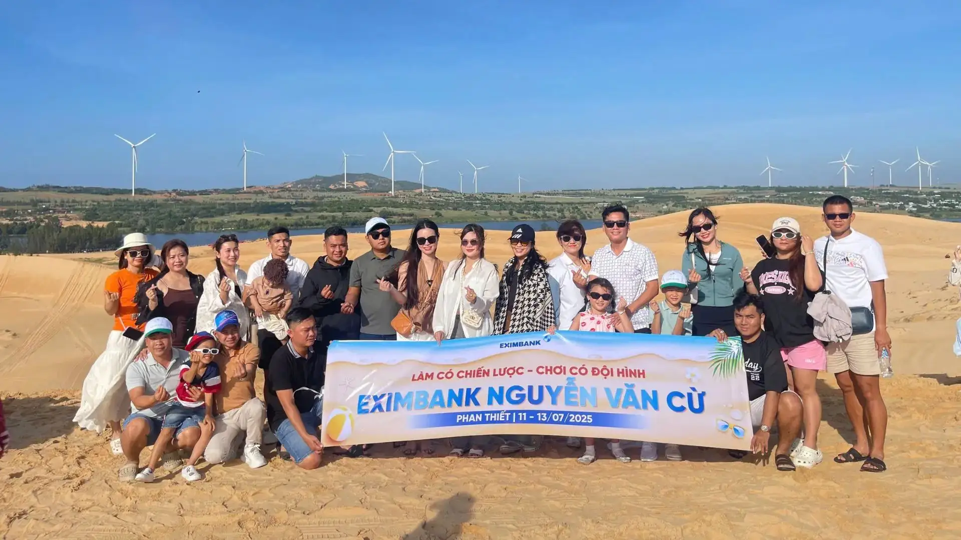Tour đoàn Eximbank Cần Thơ tại Phan Thiết check-in cùng banner Eximbank Nguyễn Văn Cừ