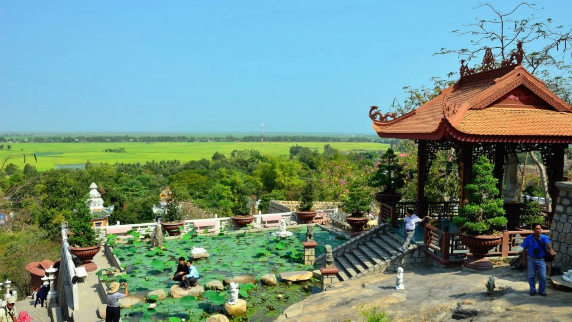Ban công Chùa Hang nhìn ra cánh đồng lúa xanh mướt dưới chân núi.